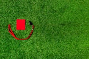 Carton rouge et sifflet sur herbe.